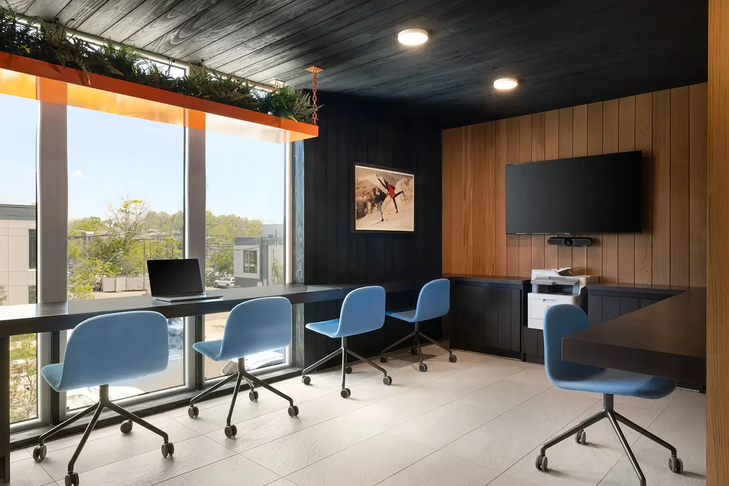 Computer room with various tables and seating, an accessible computer, printer, and TV.