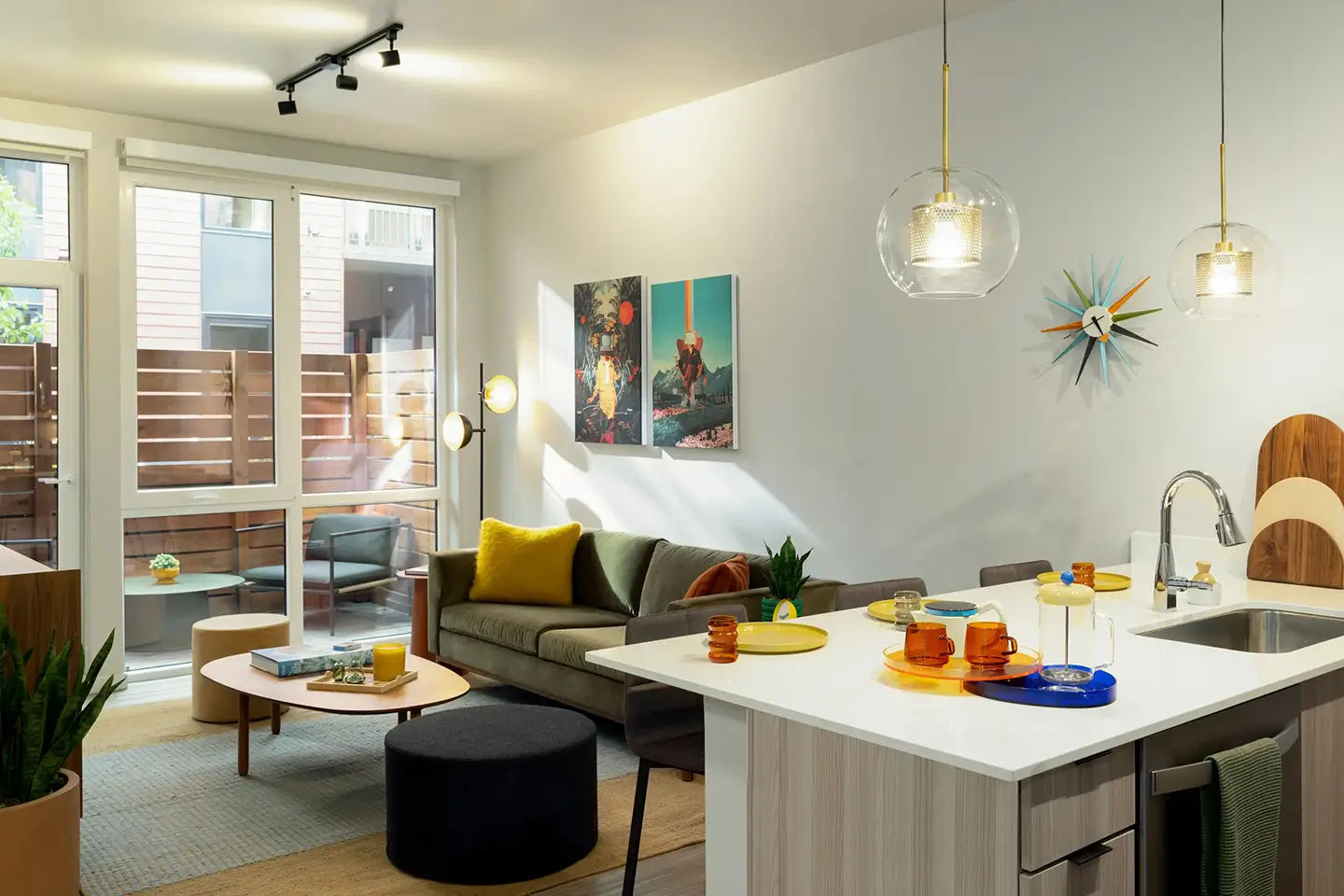 Apartment with modern decor with an open sink and bar area, couch, and access to a patio.